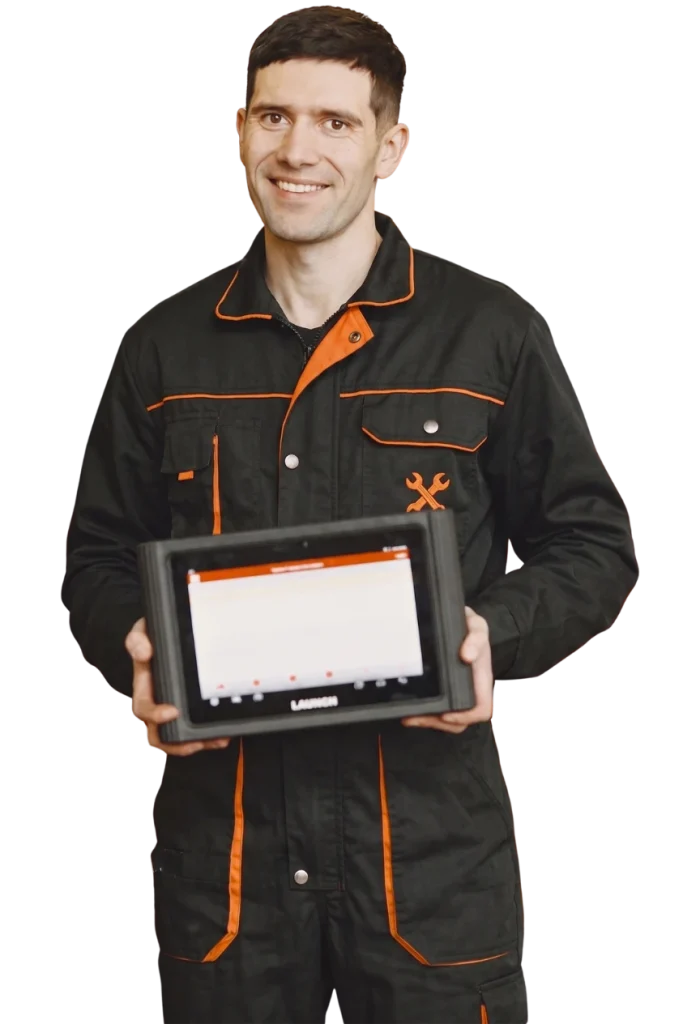 Smiling mechanic in a black uniform holding a diagnostic tablet during a Mobile Pre Purchase Auto Inspection service.